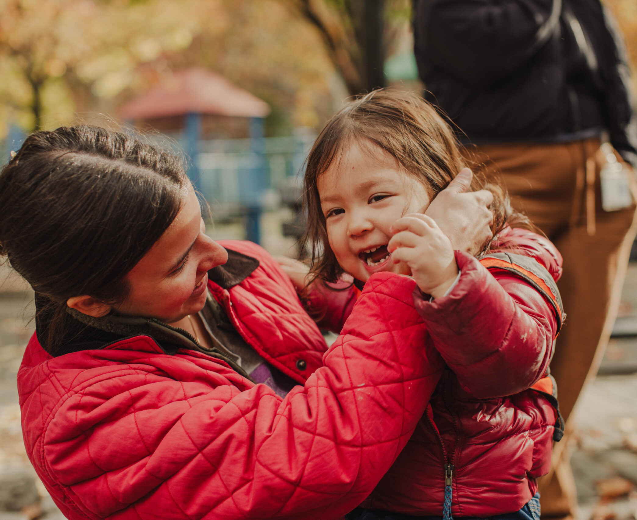 Group of children huddling over camera smiling.