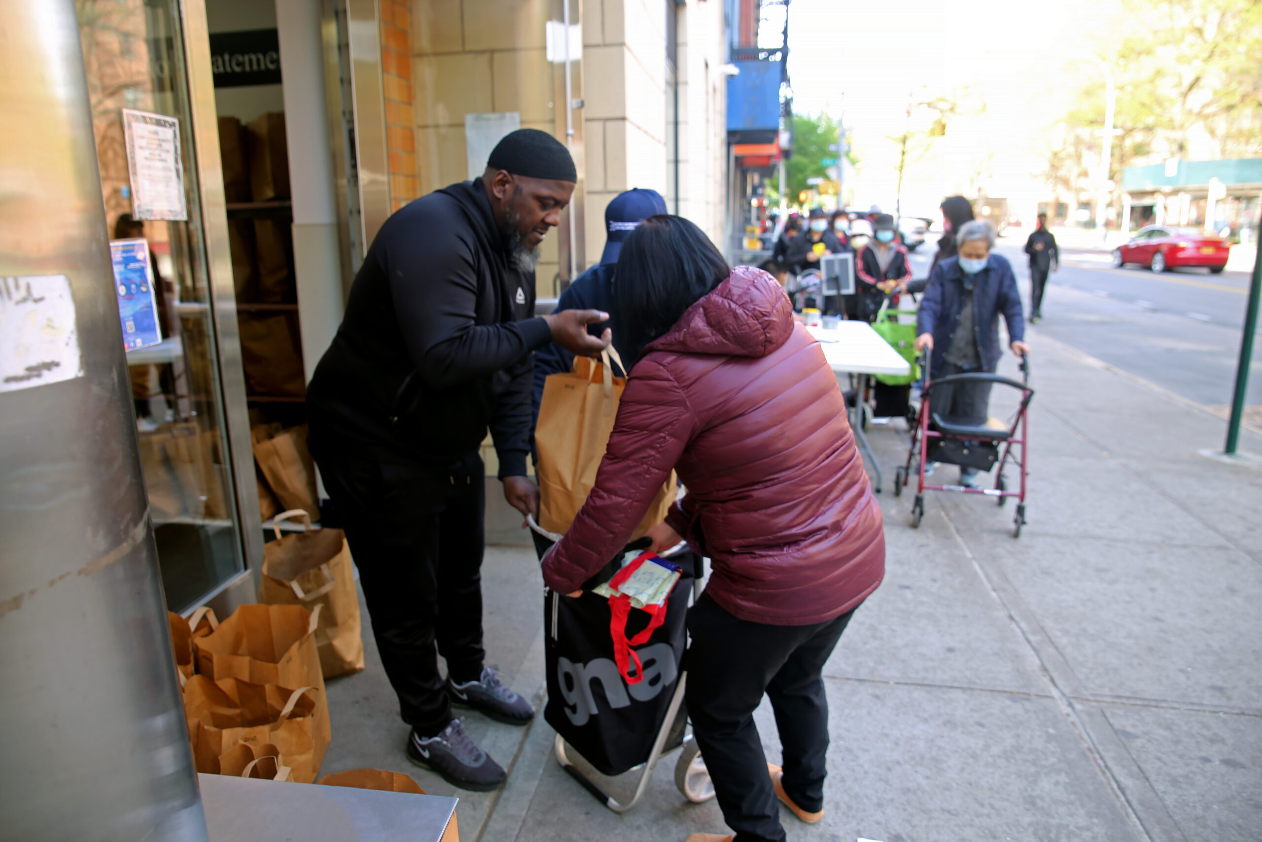 Diverse group of people smiling together while facing the camera against a sunset background.