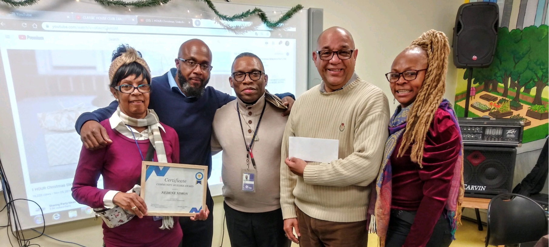 group of people standing together inside around a table at a gathering.